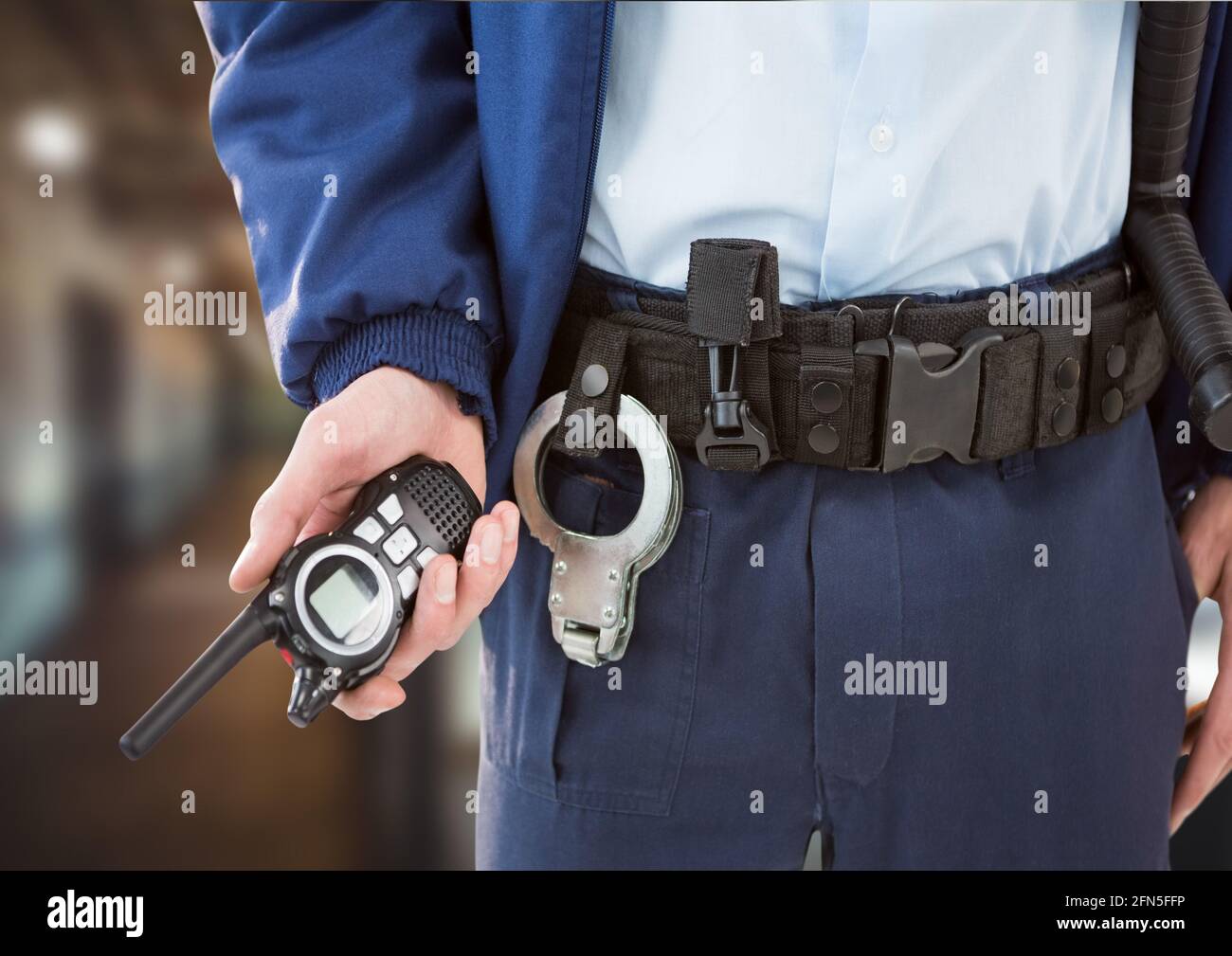 Composition de la section médiane de l'agent de sécurité mâle tenant le talkie-walkie sur un arrière-plan flou Banque D'Images