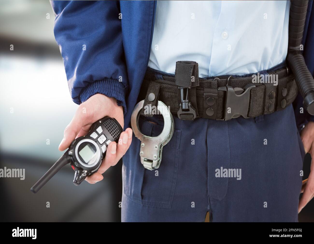 Composition de la section médiane de l'agent de sécurité mâle tenant le talkie-walkie sur un arrière-plan flou Banque D'Images