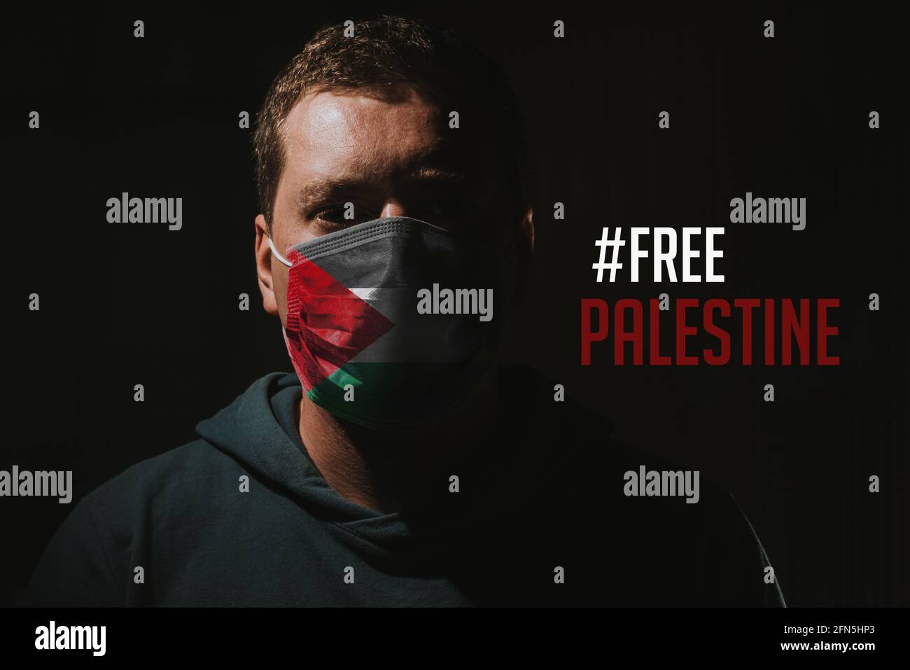 homme avec masque de visage et drapeau palestinien avec texte libre palestine Banque D'Images