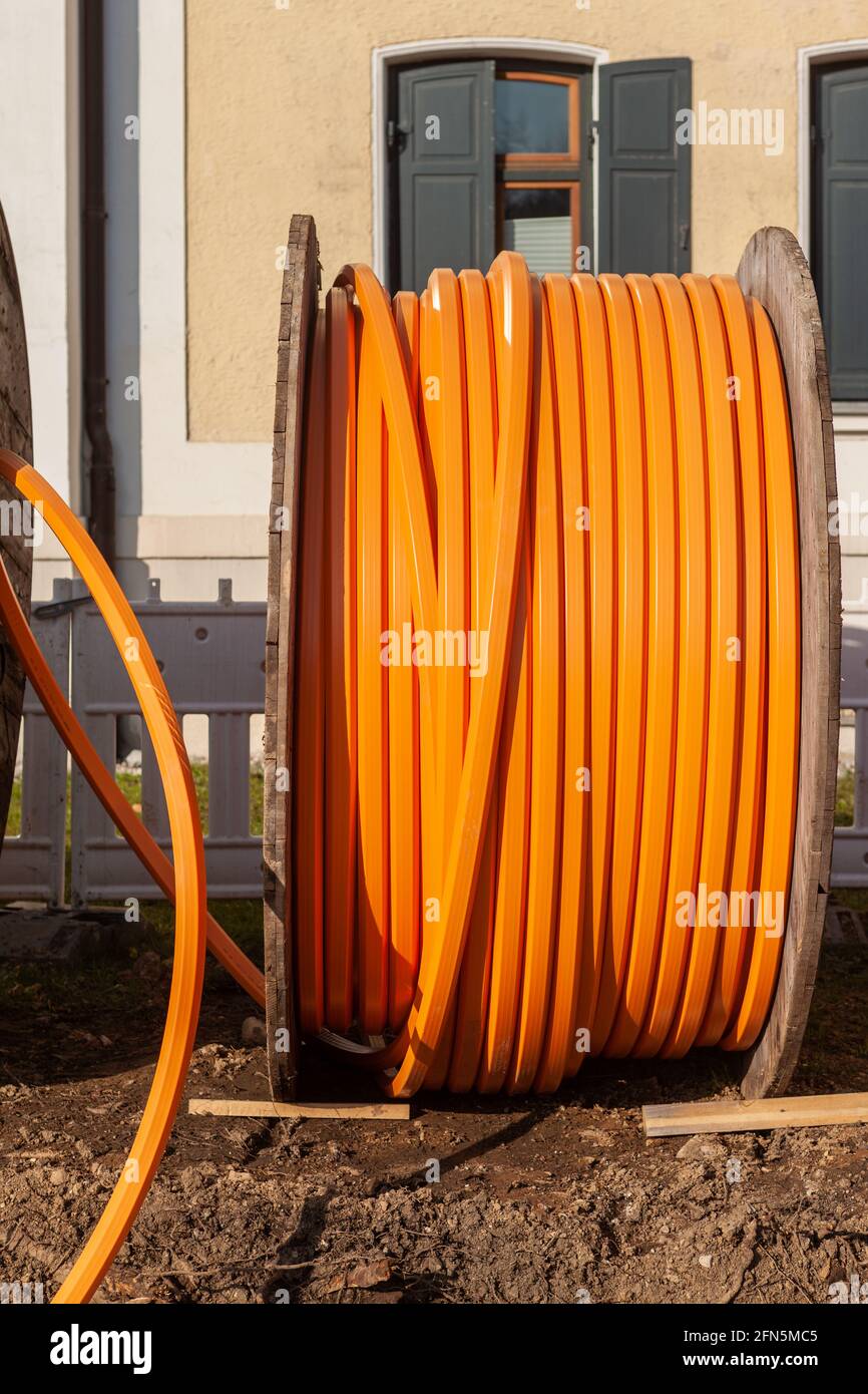 Câble téléphonique orange sur un grand rouleau en bois, câble de données en  cours de pose souterrain Photo Stock - Alamy