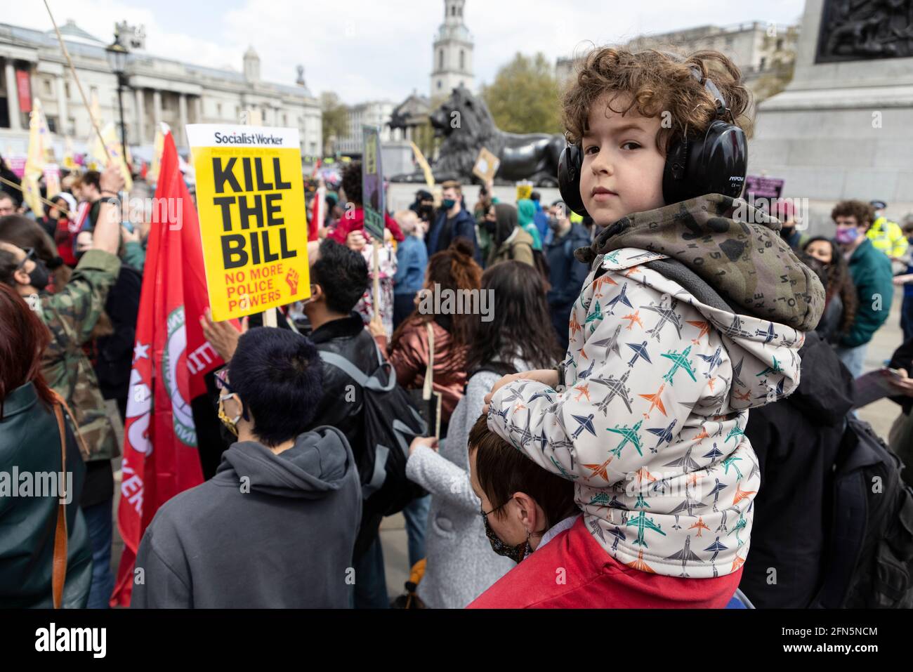 Enfant portant des couvre-oreilles et assis sur les épaules de ses parents lors de la manifestation « Kill the Bill » contre le nouveau projet de loi de police, Londres, 1er mai 2021 Banque D'Images