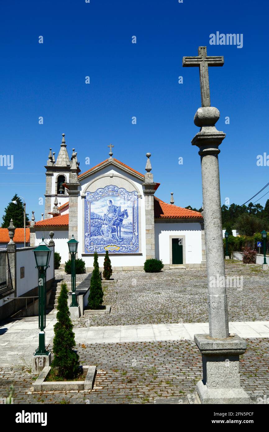 Croix de pierre sur la colonne et carreaux de céramique / azulejos sur le mur arrière de l'église San Martinho, village de Freixieiro de Soutelo, province de Minho, Portugal Banque D'Images