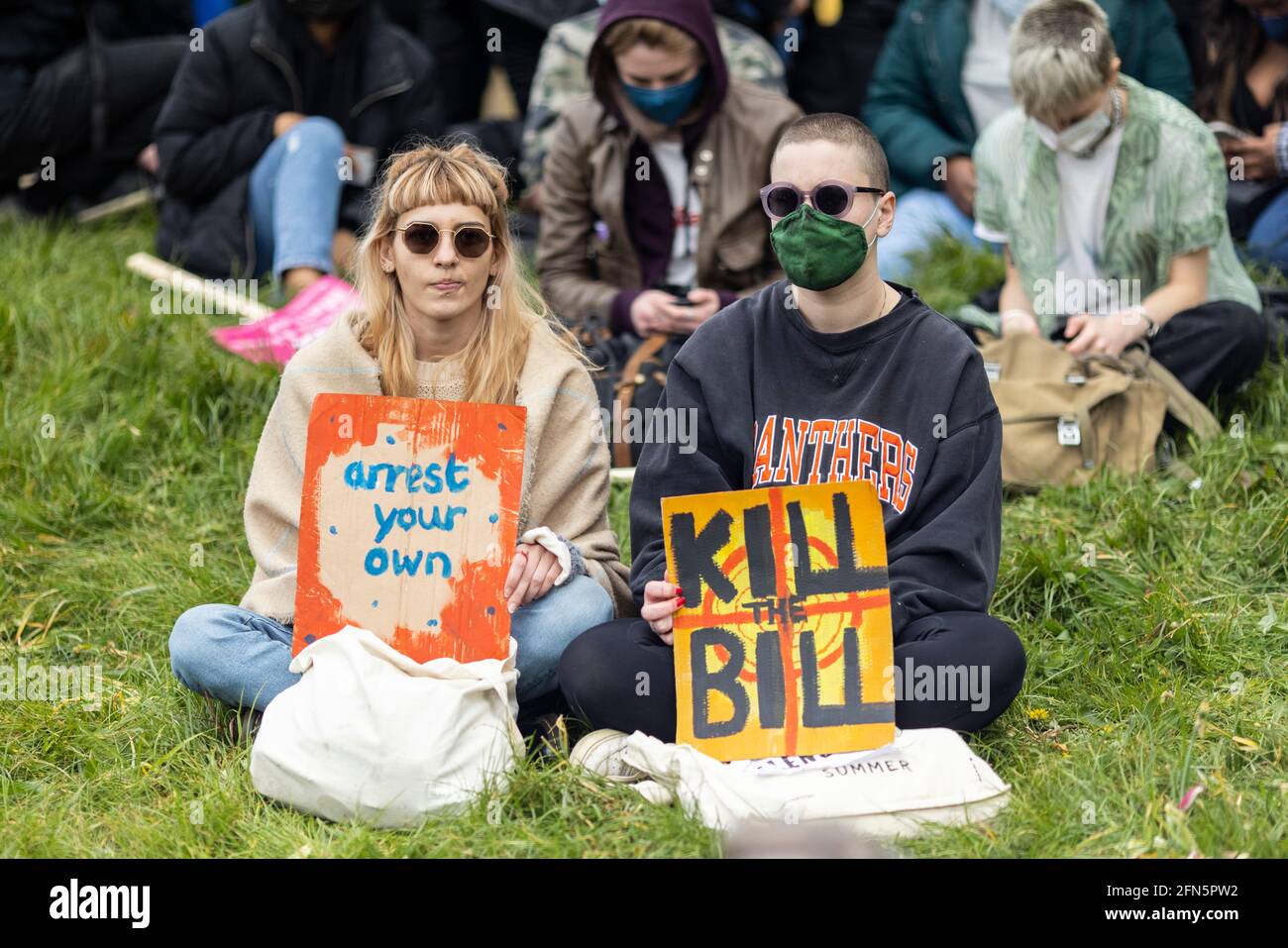 Manifestants assis sur l'herbe avec des pancartes lors de la manifestation "Kill the Bill" contre le nouveau projet de loi de police, Londres, 1er mai 2021 Banque D'Images