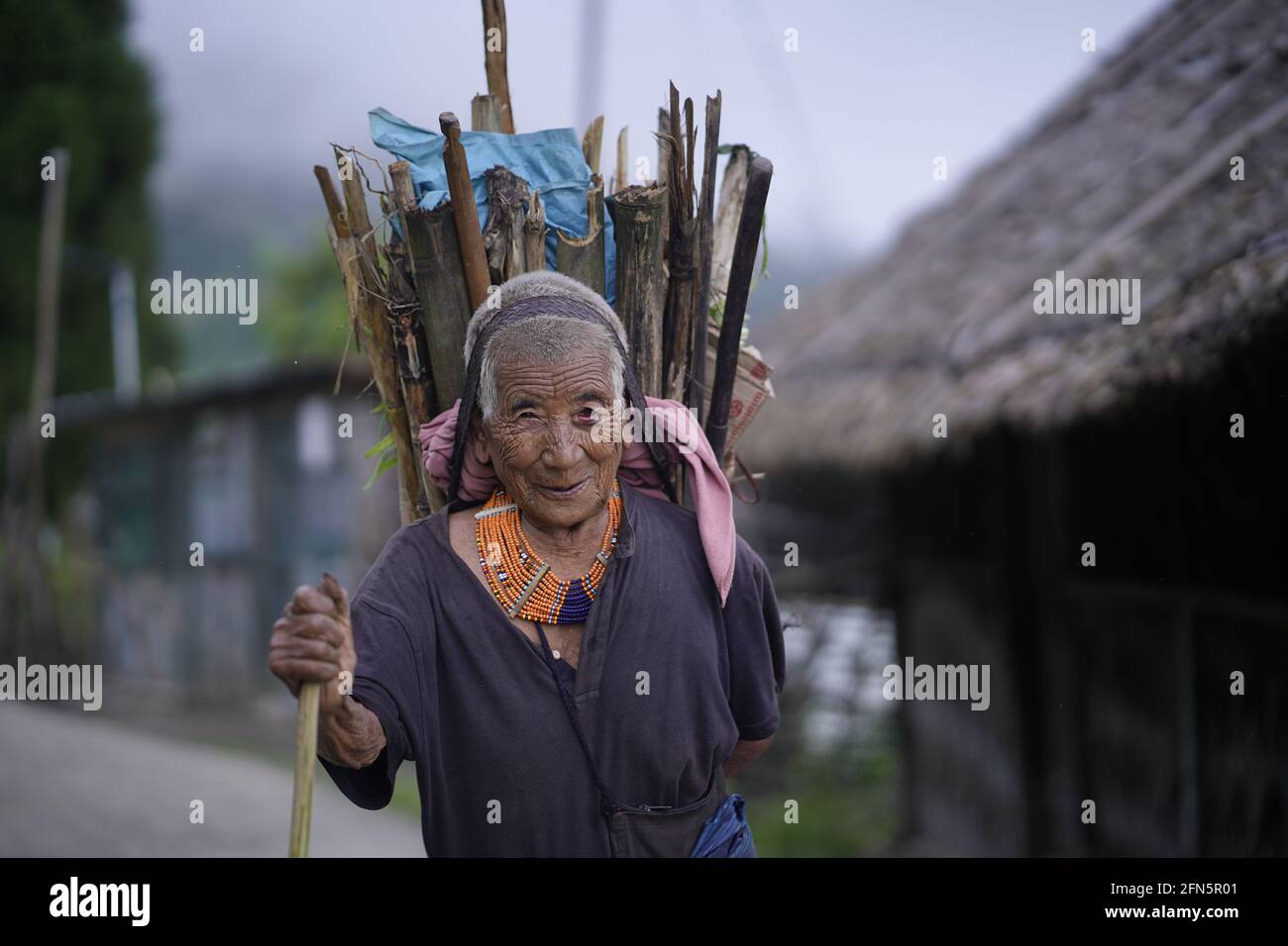 Cet homme âgé semble ne pas blesser une mouche, mais ce porte-bois était un chasseur de tête. INDE : DE SUPERBES portraits ont pris le tout Banque D'Images