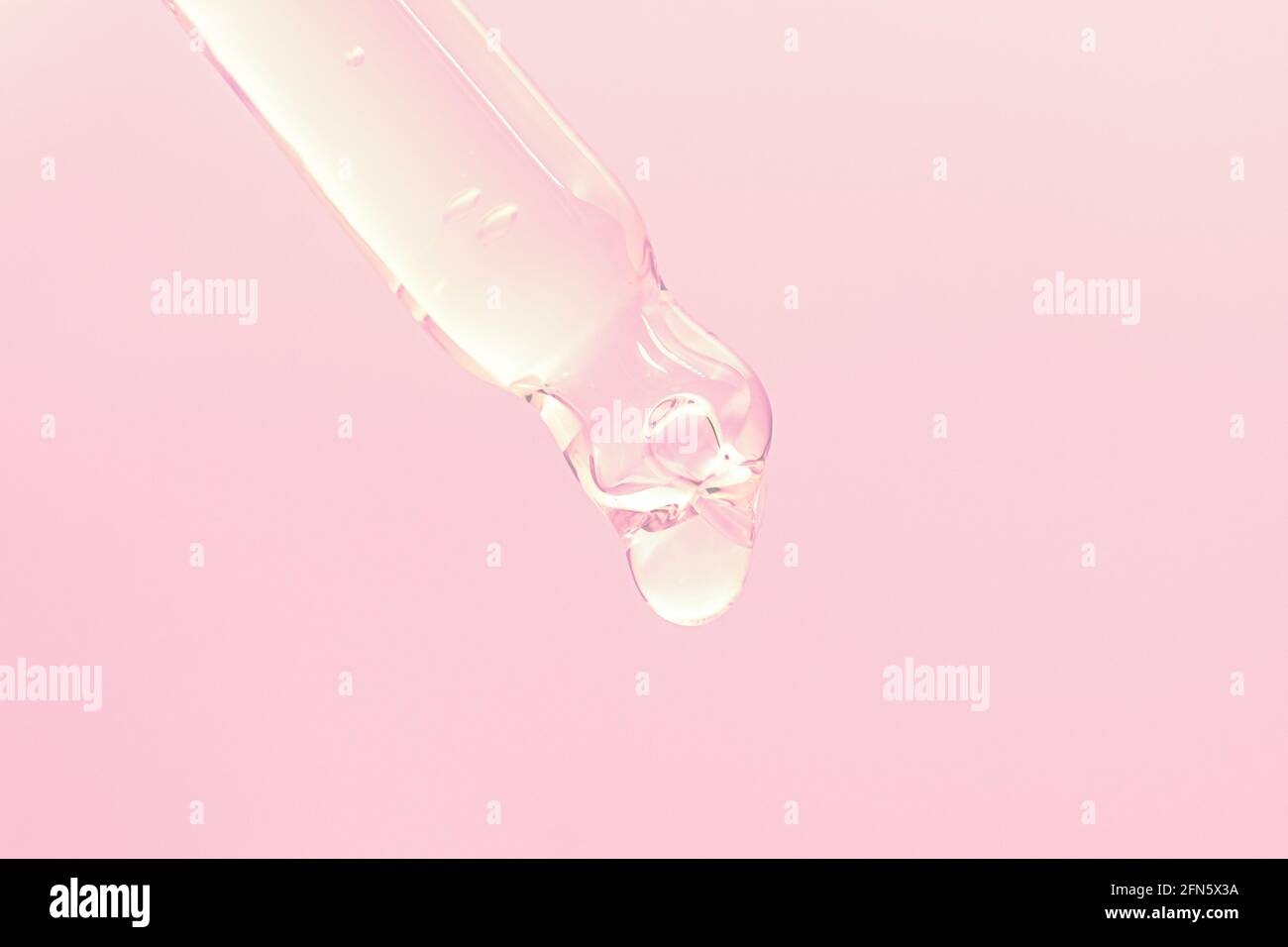 goutte de sérum face avec flacon compte-gouttes en verre et pipette sur fond rose gros plan macro facecare concept Banque D'Images
