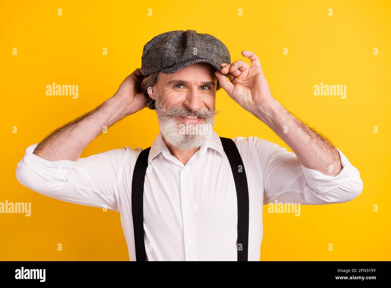 Photo portrait d'un homme barbu avec moustache en contact avec un casque souriant arrière-plan isolé de couleur jaune vif Banque D'Images
