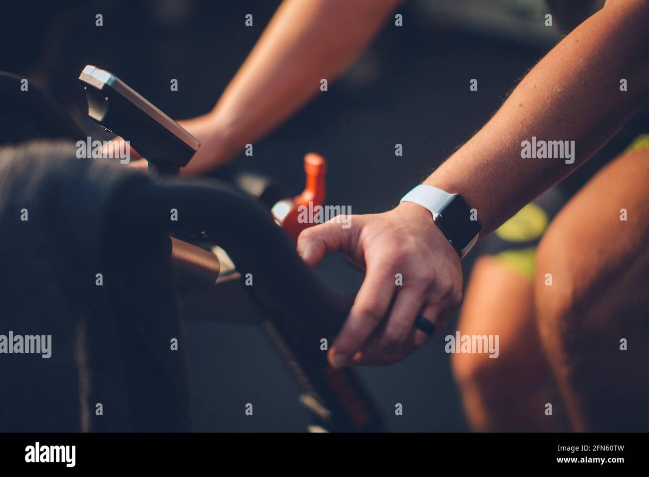 Un gros plan d'un mâle caucasien pédalant dans un studio de vélo. Banque D'Images