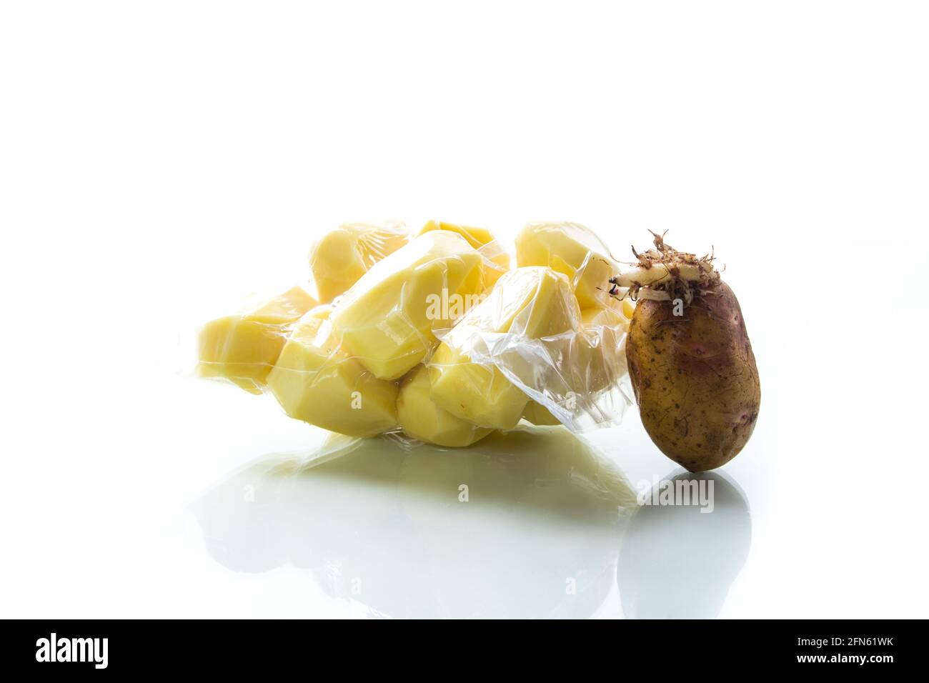 pommes de terre pelées fermées dans un sac sous vide et germées pommes de terre sur fond blanc Banque D'Images