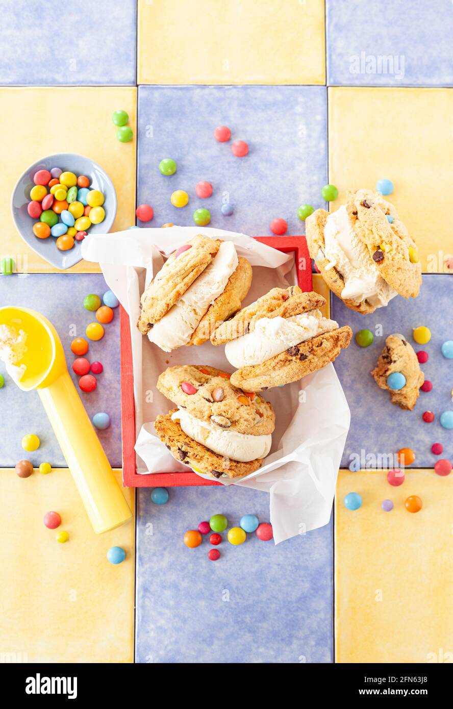 Sandwich à la crème glacée à la vanille avec biscuits aux pépites de chocolat et coloré lentilles au chocolat Banque D'Images