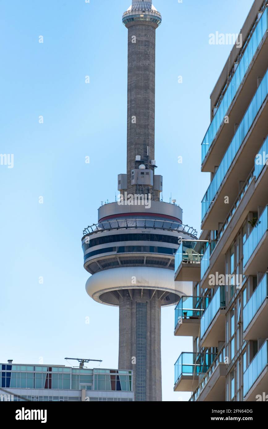 Angle inhabituel de la Tour CN dans le quartier du centre-ville de Toronto, Canada. Le monument est encadré dans deux bâtiments modernes Banque D'Images