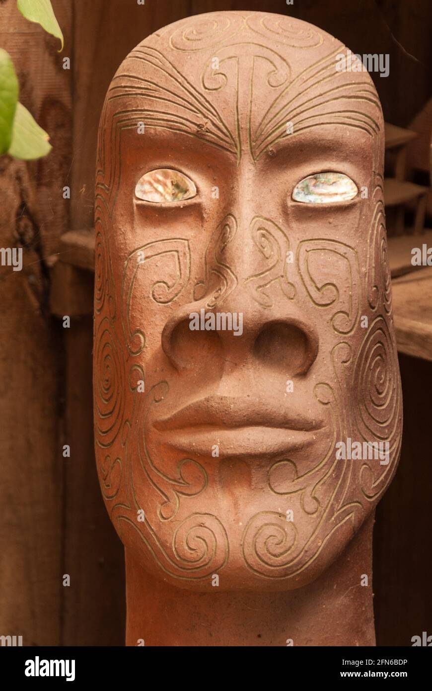 Un buste ardu en argile avec des motifs maoris-tatouage et des yeux de la nacre vu à la poterie de Driving Creek Railway qui a été fondée par le célèbre potter Barry Brickell (1935-2016) Banque D'Images
