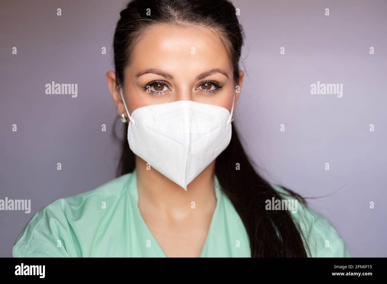 Jeune professionnel de la santé, infirmière avec masque de protection. Isolé sur fond gris Banque D'Images
