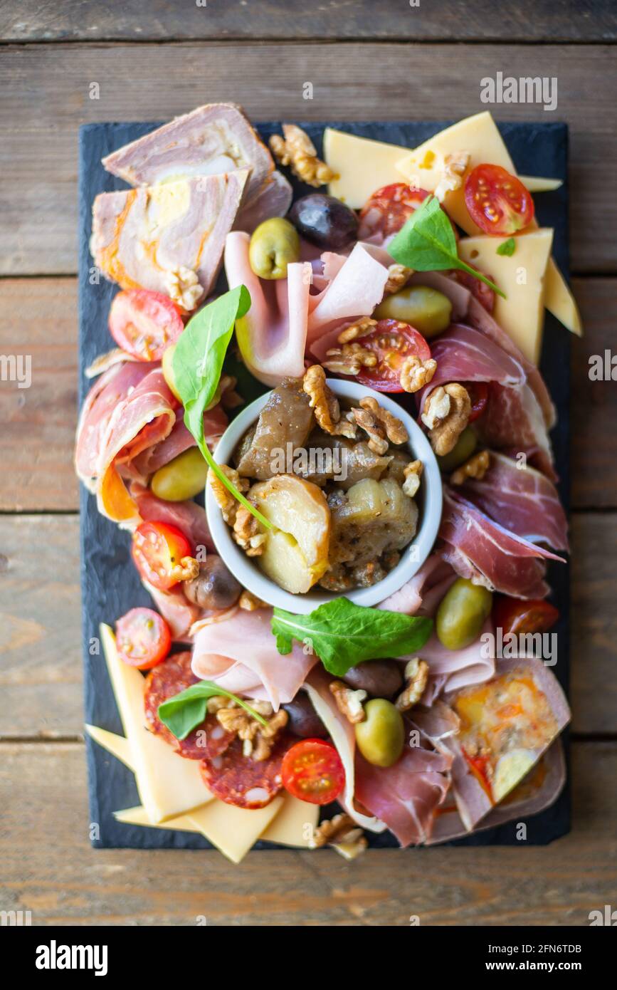 table pleine de produits méditerranéens tels que noix, jambon, fromage, olives, tomate, aubergine., olives, tomate, aubergine. Banque D'Images