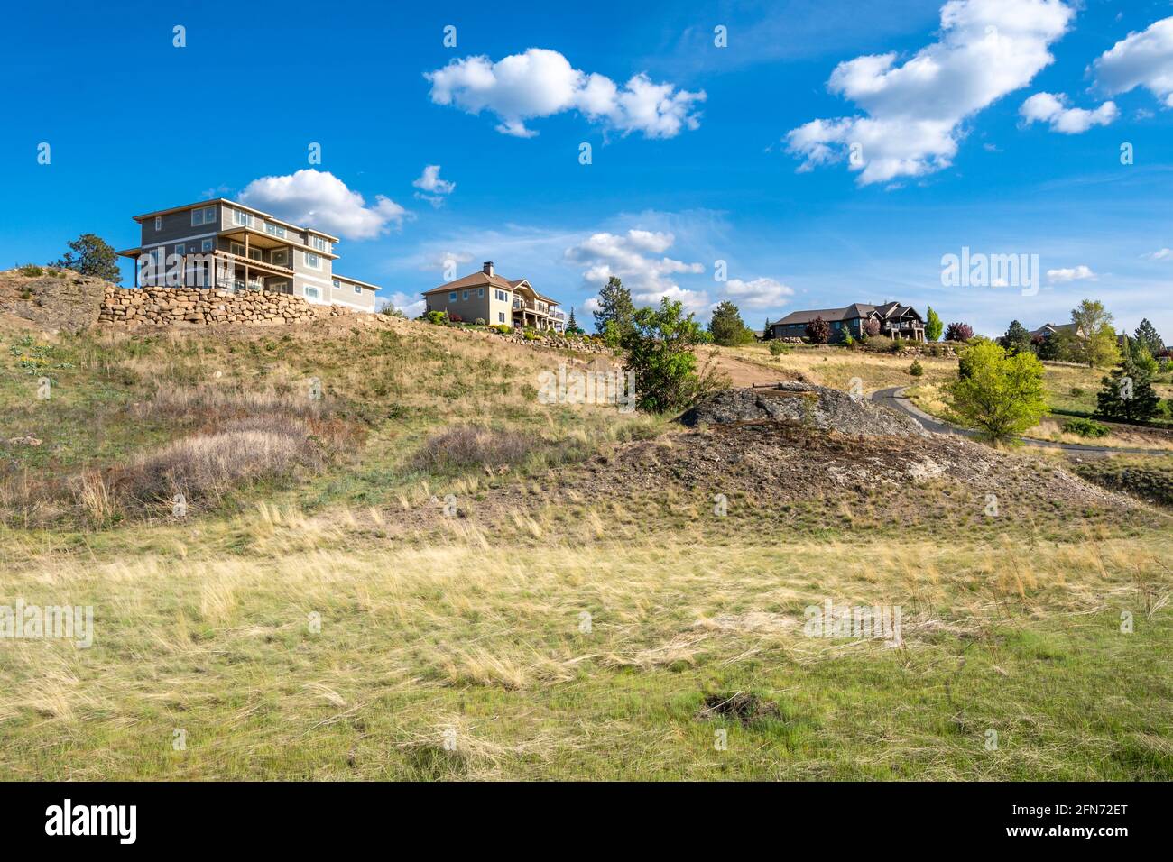 Une nouvelle maison de construction à côté de maisons de luxe existantes au sommet d'une colline dans la ville de Liberty Lake, Washington, une banlieue de Spokane, Washington Etats-Unis Banque D'Images