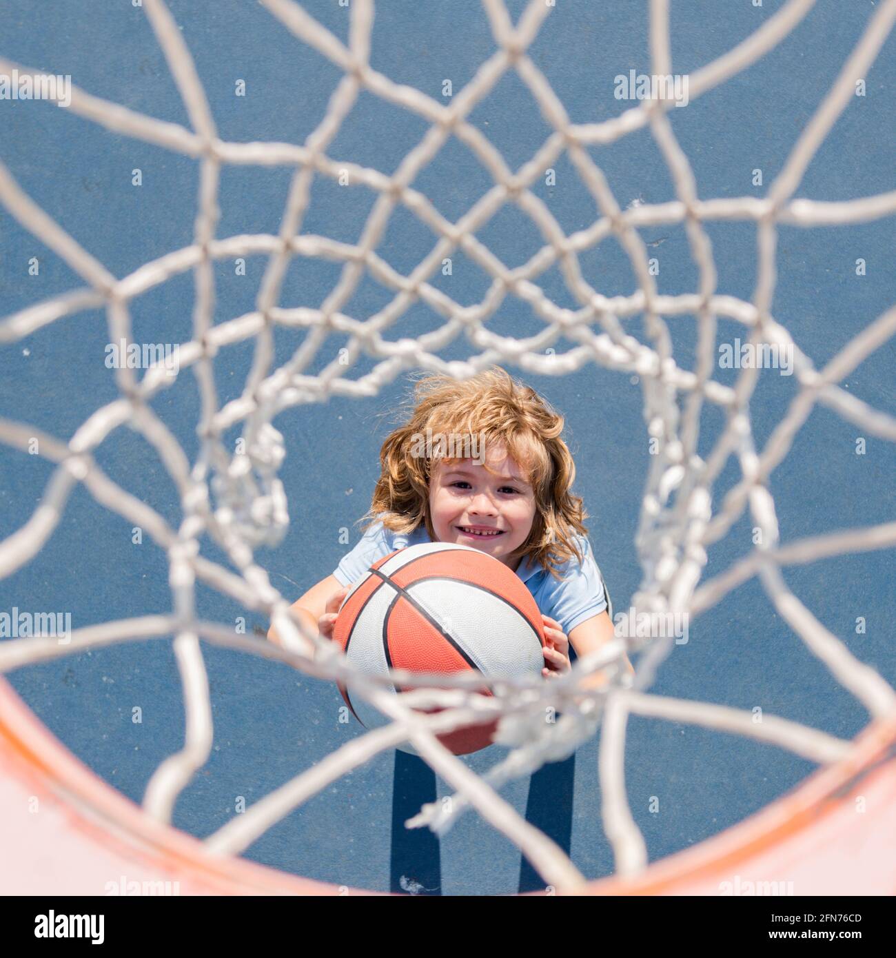 Vue de dessus de l'enfant mignon joue au basket-ball. Enfants actifs qui jouent en plein air avec un ballon de basket-ball. Banque D'Images