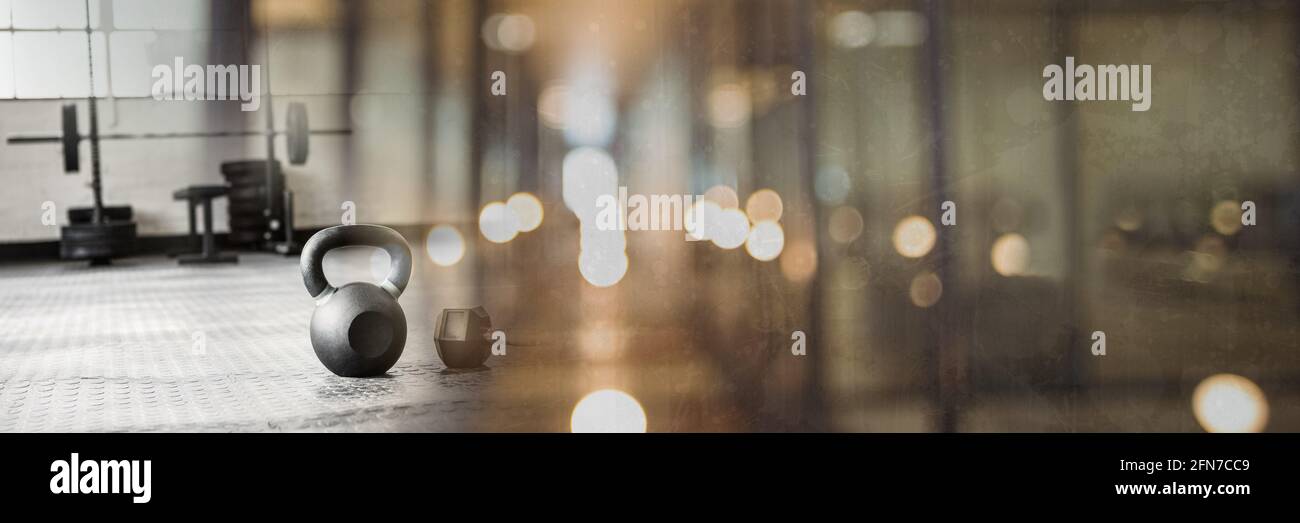 Composition de kettlebell sur le sol de la salle de sport avec lumière grise floue Banque D'Images