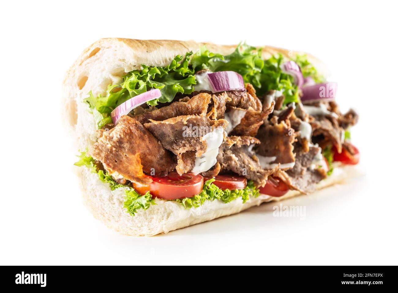 Baguette de kebab turque isolée avec une généreuse portion de légumes et une viande de veau ou de poulet correctement grillée. Banque D'Images