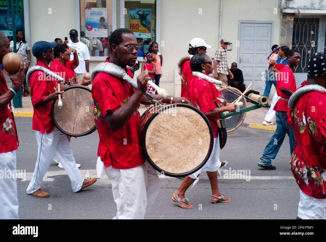 Marigot, Saint Martin - 14 2013 juillet : défilé pour le 14 juillet ou Quatorze Juillet avec un batteur jouant un ballon de basse d'un groupe créole afro-antillais. Banque D'Images