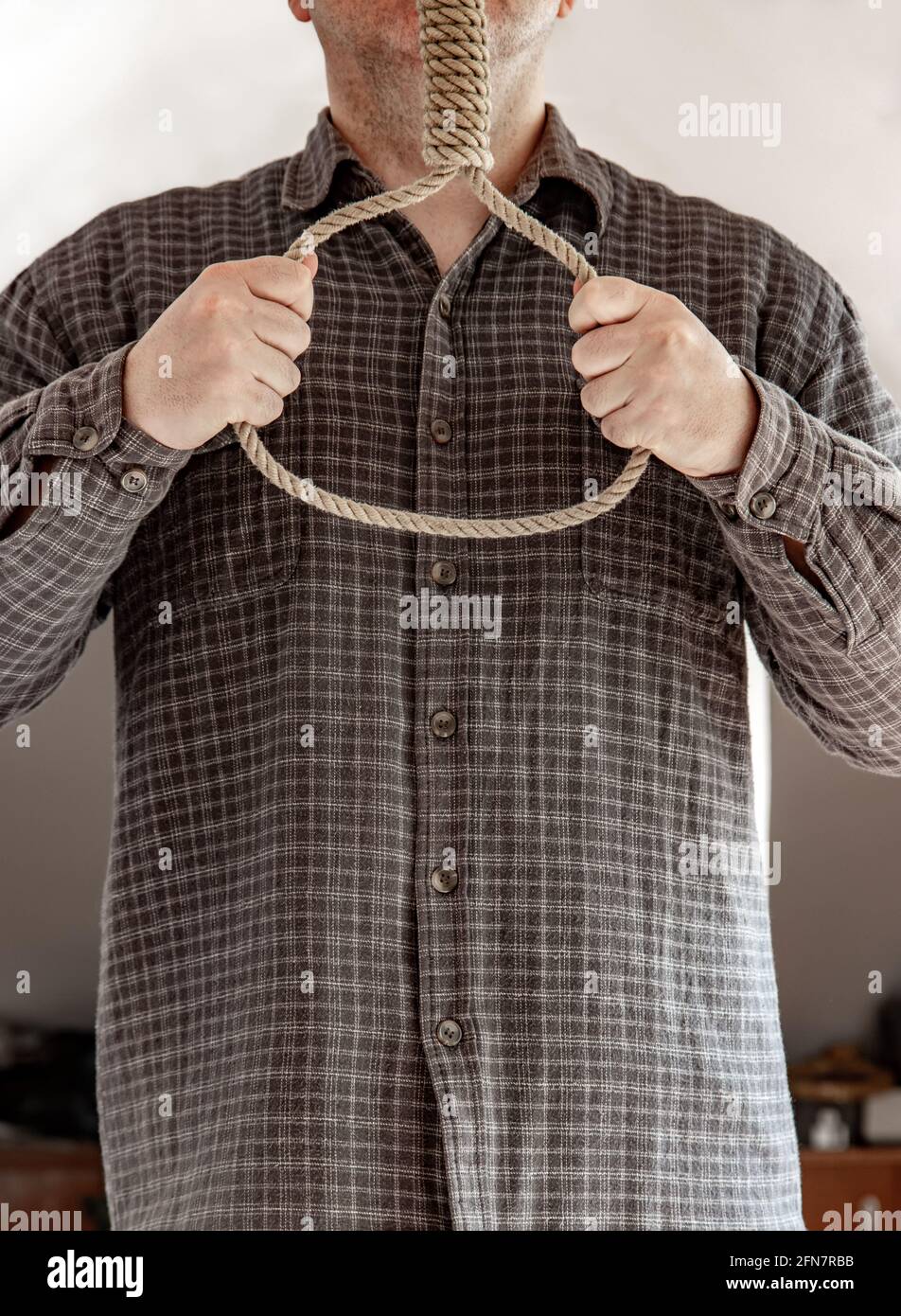 Un homme tenant un nœud dans une chambre mansardée Banque D'Images