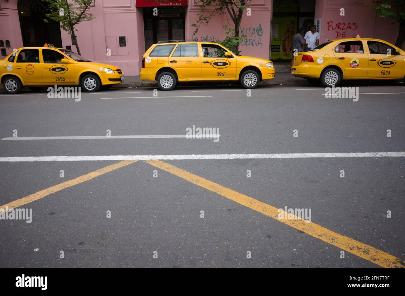 Cordoba, Argentine - janvier, 2020: Parking municipal jaune de taxi en file d'attente pour les clients de passagers sur la route vide rue à l'arrière-plan Banque D'Images