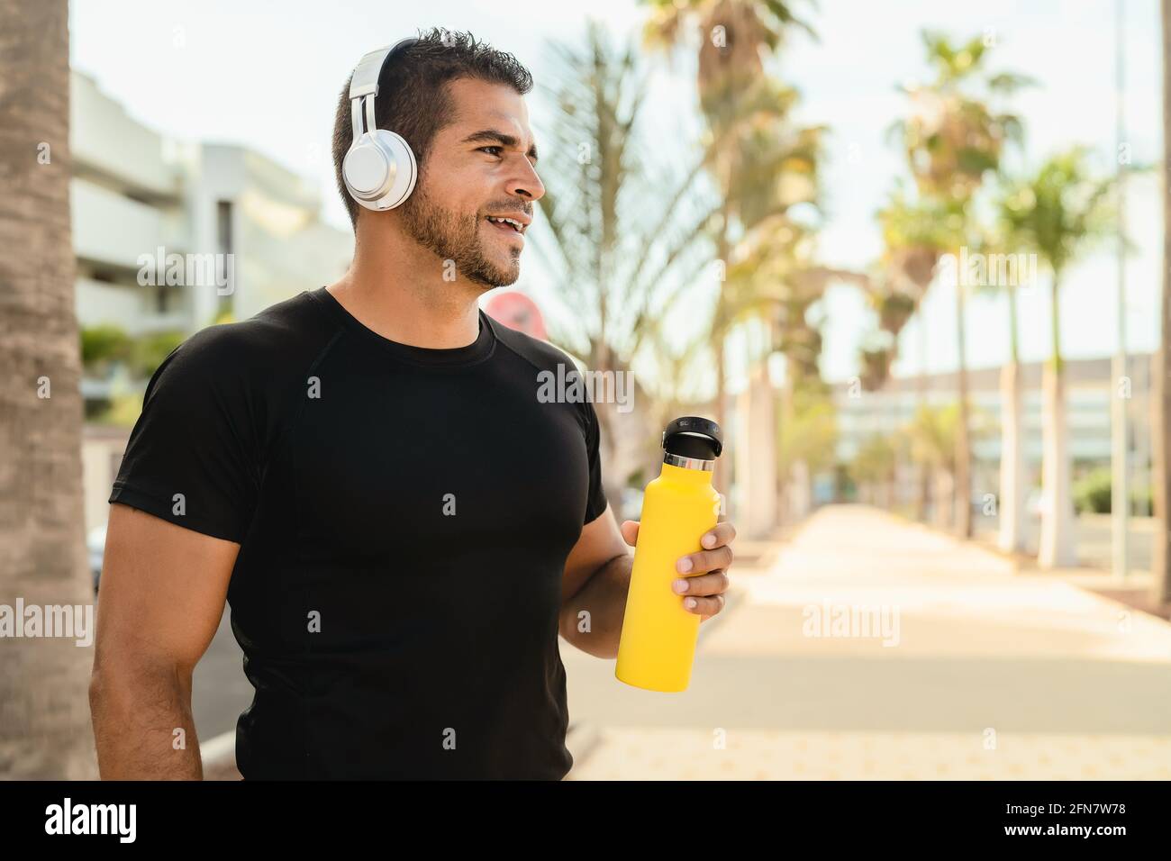 Latin homme faisant le jogging et la routine d'entraînement tout en écoutant de la musique avec casque d'extérieur sans fil Banque D'Images