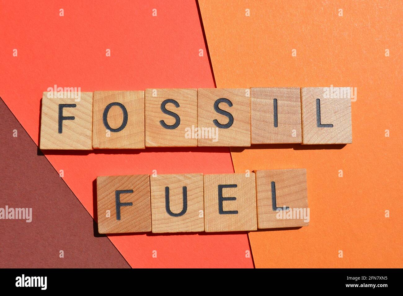 Combustible fossile, mots en lettres de l'alphabet en bois isolées sur fond rouge Banque D'Images