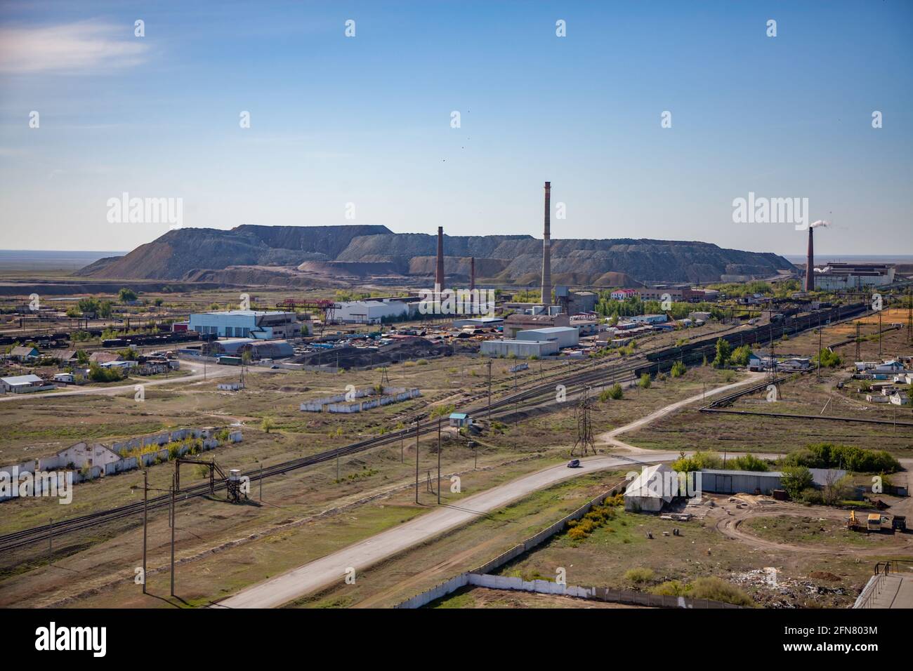 Vue aérienne sur la gare, la route, les cheminées de l'usine de traitement et thermoélectrique, et les décharges minières à l'horizon. Ciel bleu. Banque D'Images