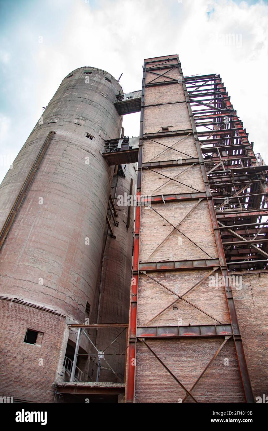 Temirtau, Kazakhstan : usine de ciment soviétique dépassée. Vue sur le silo de ciment et la structure métallique. Ciel bleu. Banque D'Images