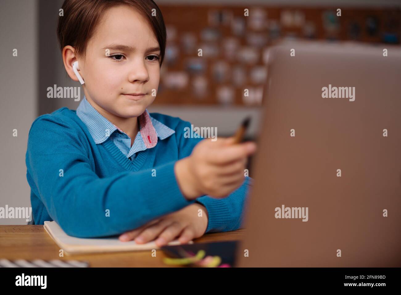 Un garçon de Preteen utilise un ordinateur portable pour faire des cours en ligne. E-Education à distance, enseignement à domicile. Banque D'Images