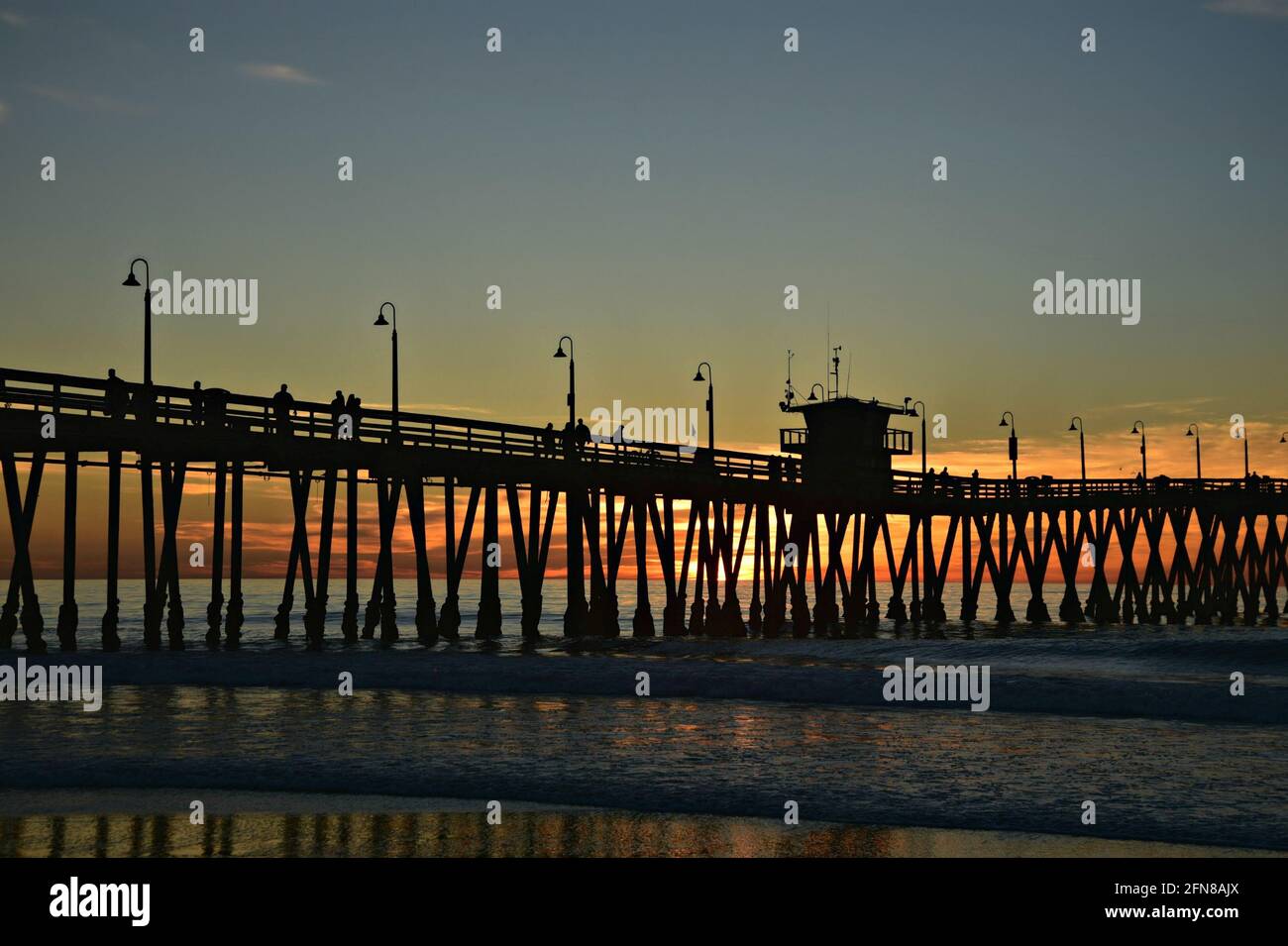 Coucher de soleil sur la mer avec vue panoramique sur les silhouettes des gens sur l'Imperial Beach Pier à San Diego, Californie, États-Unis. Banque D'Images