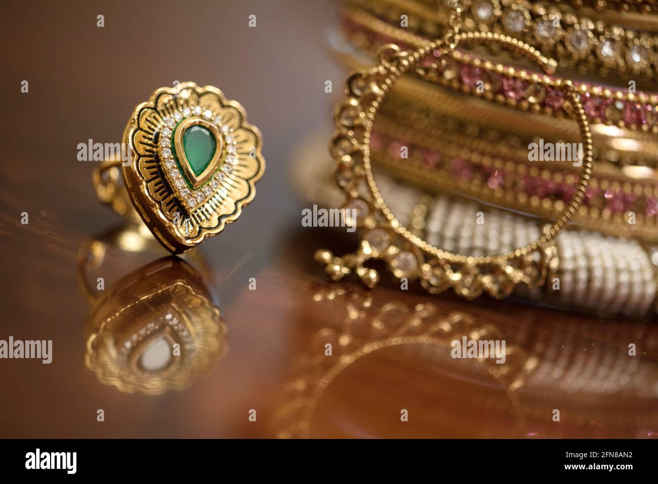 Bague dorée avec pierre verte et bracelets indiens Banque D'Images