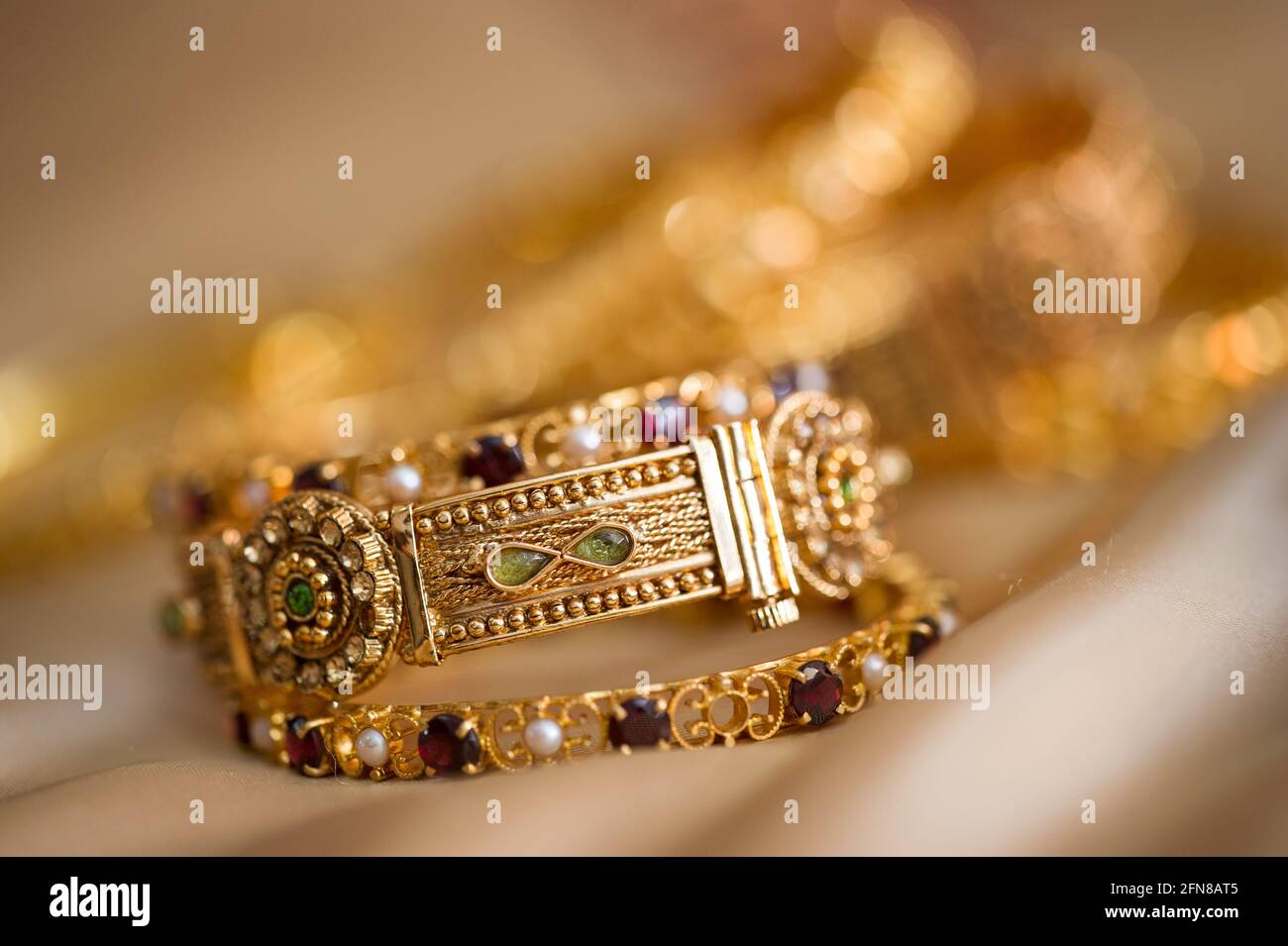 Beaux bracelets dorés décorés de pierres et de sculptures Banque D'Images