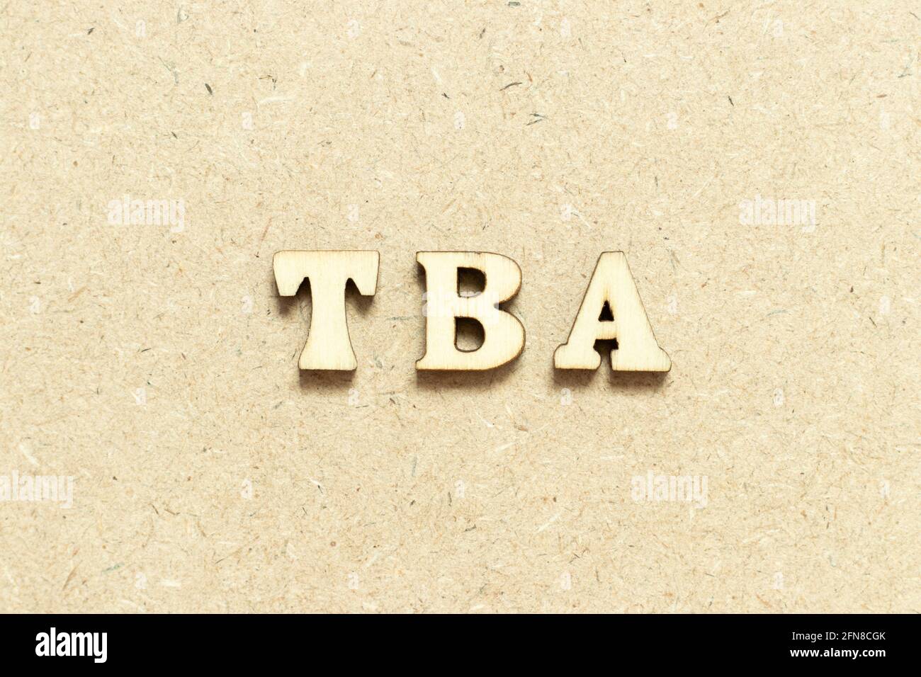 Lettre alphabétique du mot TBA (abréviation de à annoncer) sur fond de bois Banque D'Images