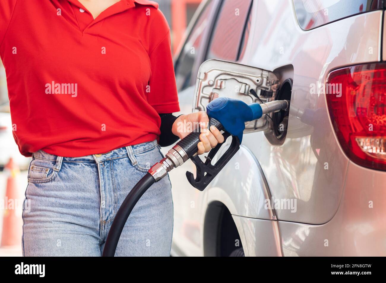 Personnel de la station-service employé travaillant entretien recharge voitures moteur à essence carburant au voyageur Banque D'Images