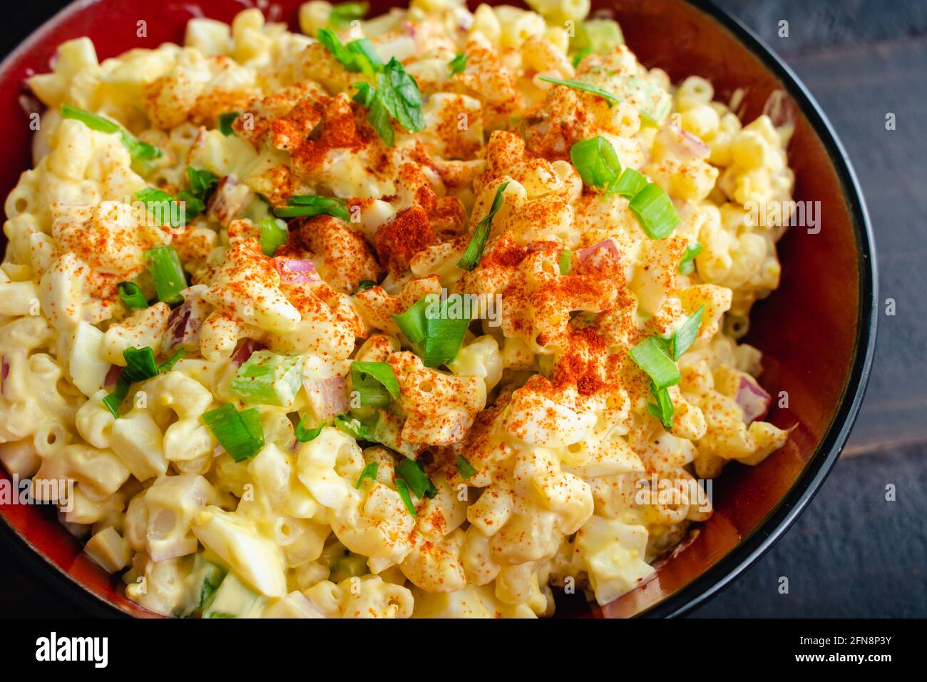 Salade de pâtes aux œufs décomposés dans un bol de service : un grand bol de salade de macaroni à base d'œufs durs Banque D'Images