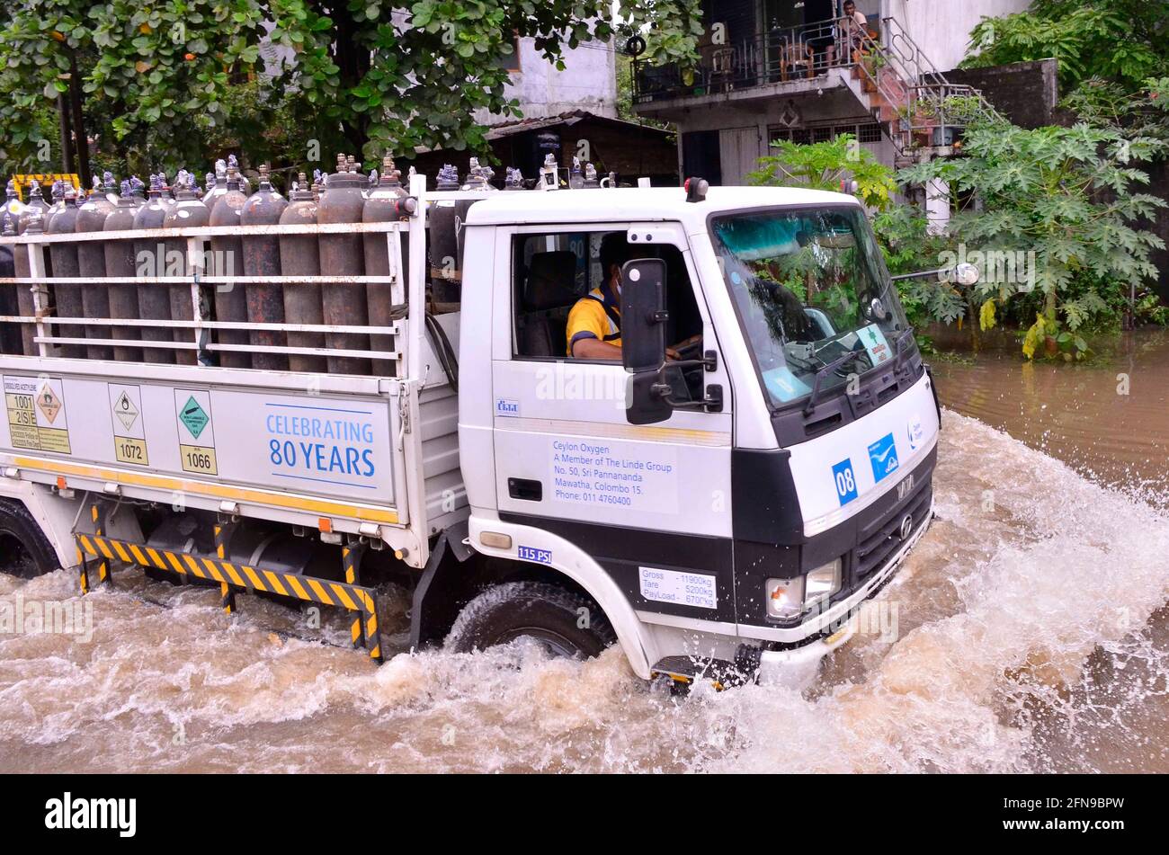 Colombo, Sri Lanka. 15 mai 2021. Un camion transportant des bouteilles d'oxygène se déplace le long d'une route inondée à Gampaha, Sri Lanka, le 15 mai 2021. Au moins quatre personnes sont mortes et plus de 42,000 autres ont été touchées par des jours de vents forts et de fortes pluies qui ont frappé le pays en raison de la formation d'un super cyclone dans la baie du Bengale, Le Centre de gestion des catastrophes du Sri Lanka (DMC) a déclaré samedi dans son dernier rapport météorologique. Credit: Gayan Sameera/Xinhua/Alay Live News Banque D'Images