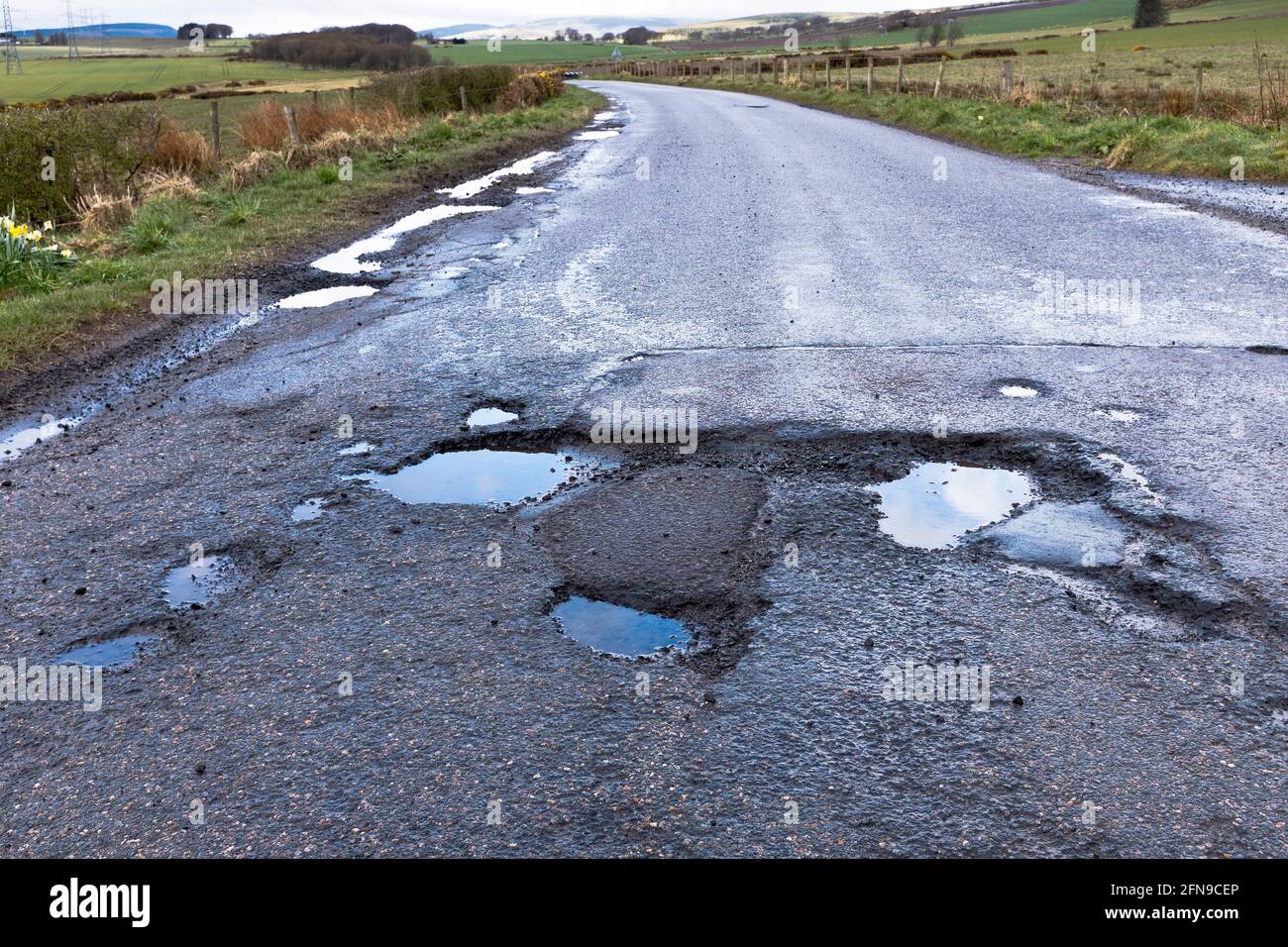 dh Roads ECOSSE Royaume-Uni trou profond route flaque endommagé surface après Covid 19 hiver dommages des nids-de-poule en gros plan pays de la pothole mauvaise qualité Banque D'Images