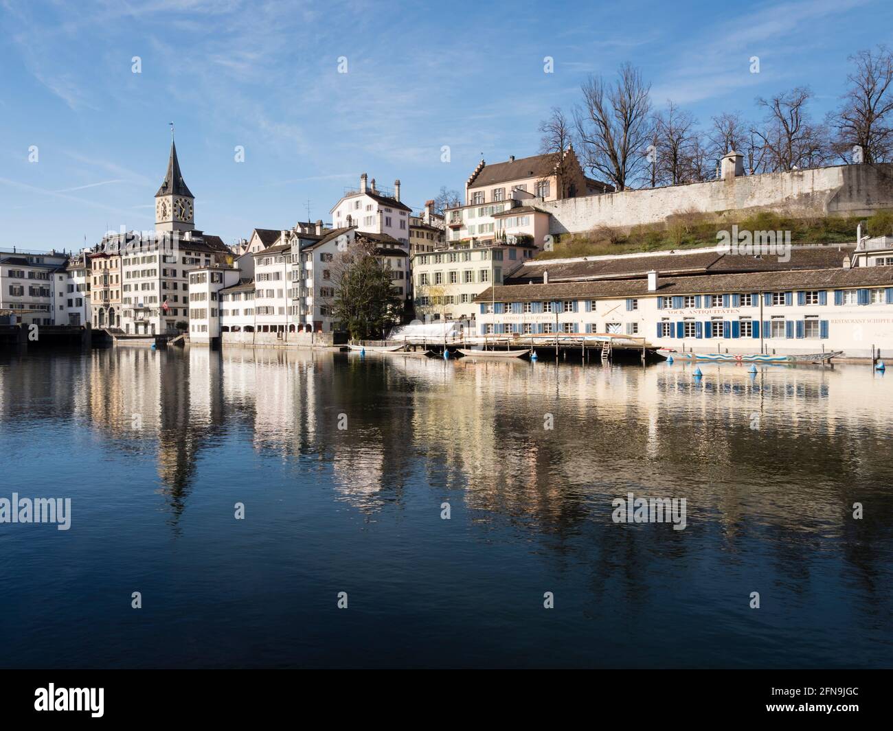 Front de mer de la rivière Limmat dans la vieille ville de Zurich, Suisse. Vue vers l'ouest depuis Limmatquai vers Lindenhof et l'église Saint-Pierre. Banque D'Images