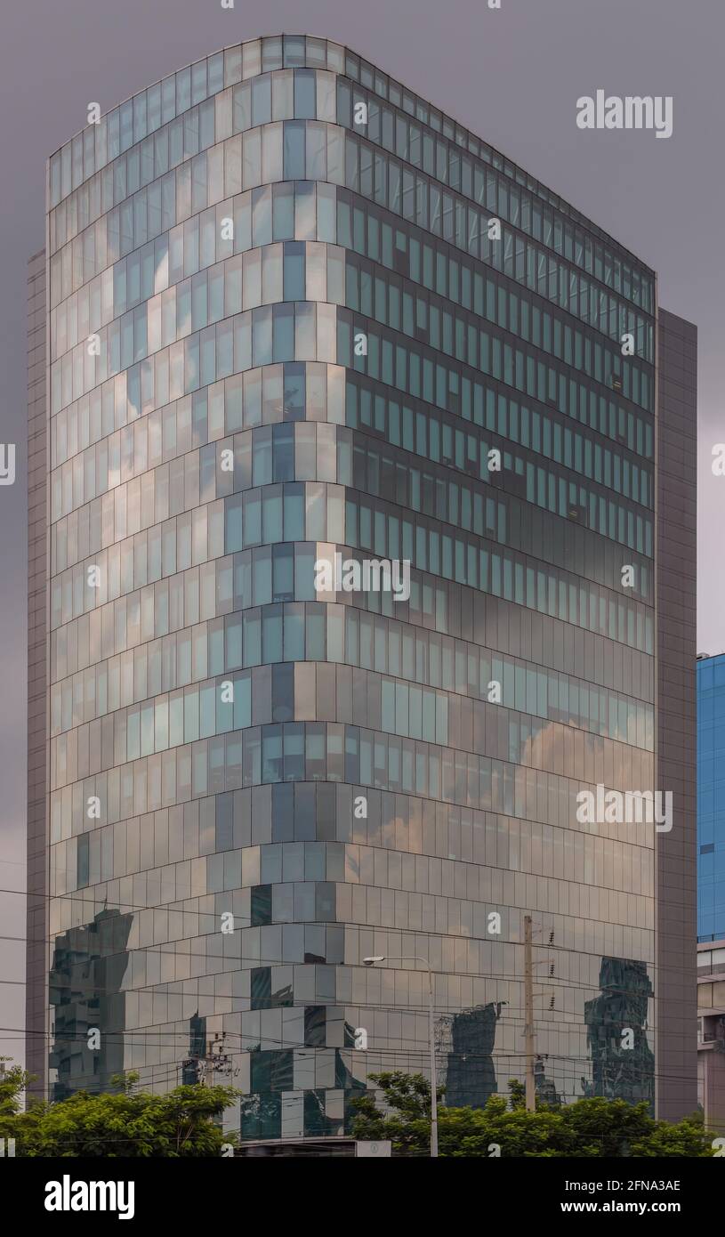 Le revêtement en verre de la tour de bureau reflète un magnifique ciel de l'après-midi. Reflet du ciel sur un bâtiment moderne en verre. Mise au point sélective. Banque D'Images