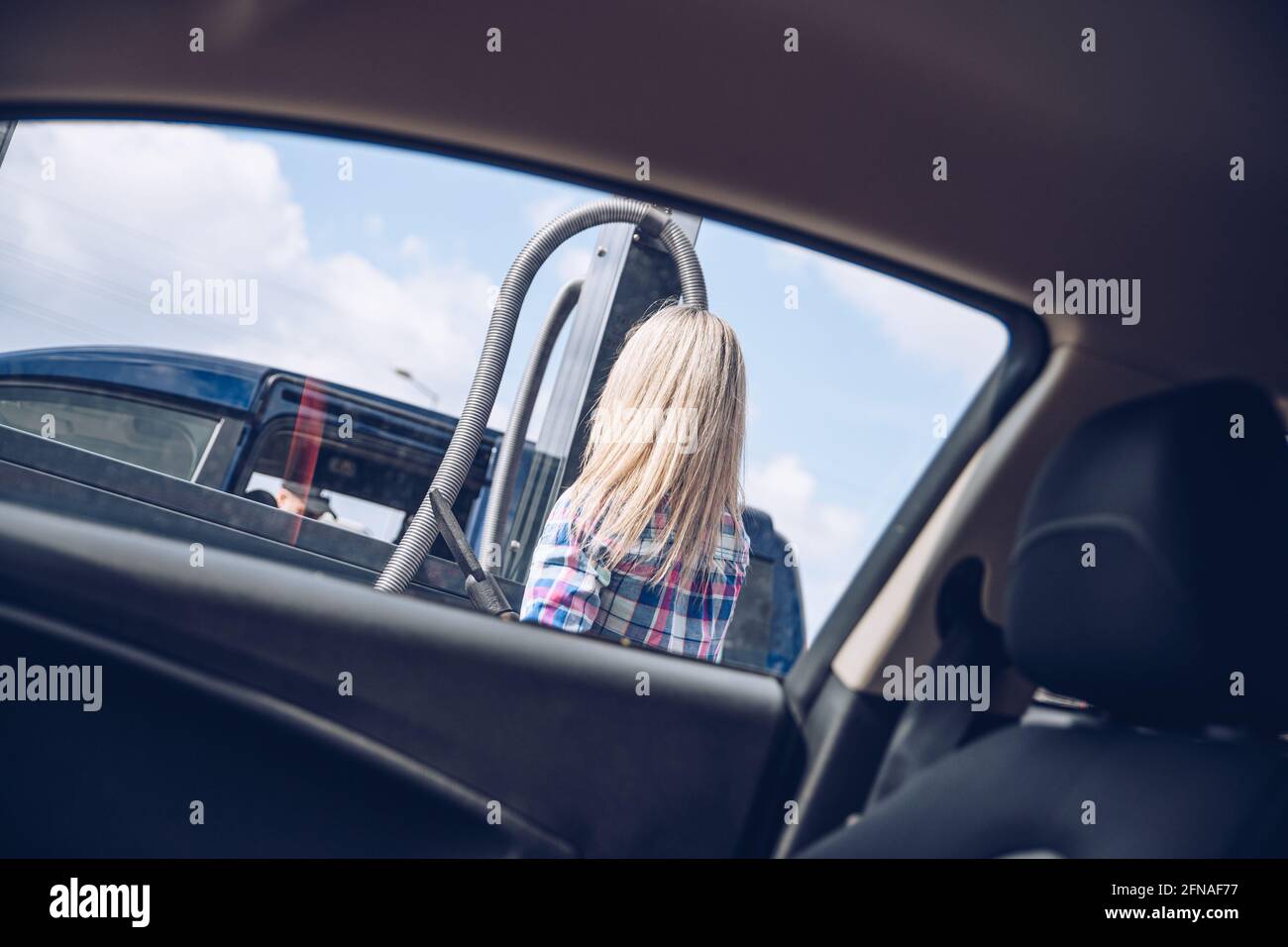 Femme payant des pièces de monnaie à la machine automatique d'aspirateur de  voiture en libre-service Photo Stock - Alamy