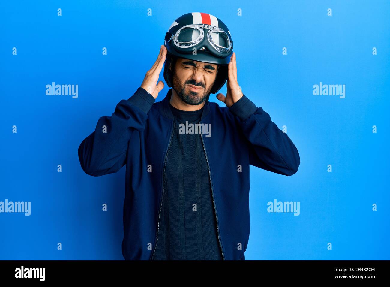 Jeune hispanique tenant un casque de moto souffrant de maux de tête  désespérés et stressés parce que la douleur et la migraine. Mains sur la  tête Photo Stock - Alamy