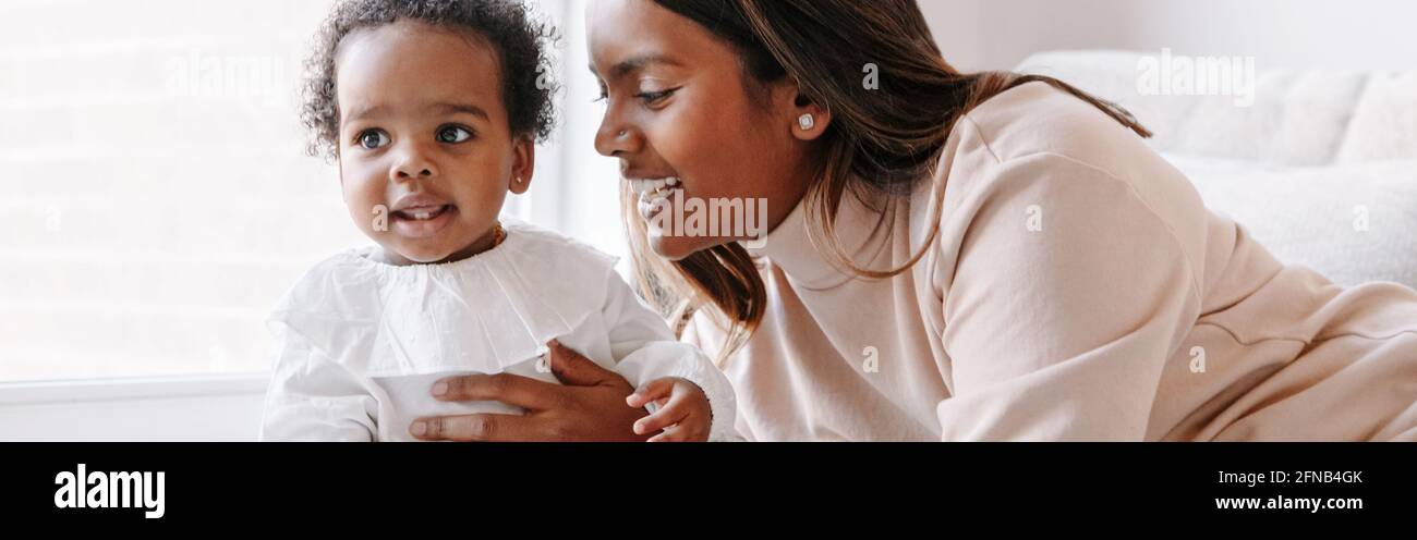Joyeux Sourire Jeune Mere Indienne Jouant Avec Fille Noire De Bebe Fille La Famille A Melange Les Gens De Race Maman Et Enfant Ensemble Style De Vie Authentique Et Sincere Photo Stock