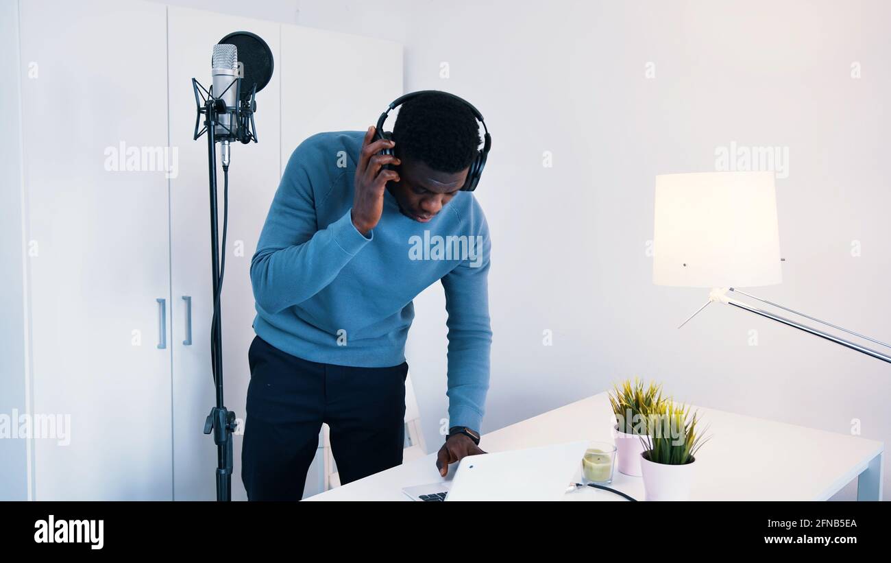 Homme portant un casque chantant une chanson dans un microphone dans un studio d'enregistrement. Photo de haute qualité Banque D'Images