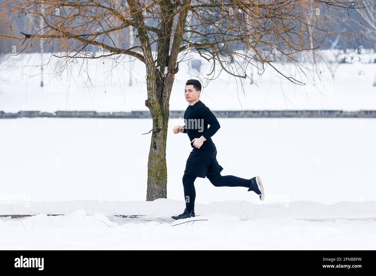 Le jeune homme fait du jogging en hiver tout en faisant du sport. Banque D'Images