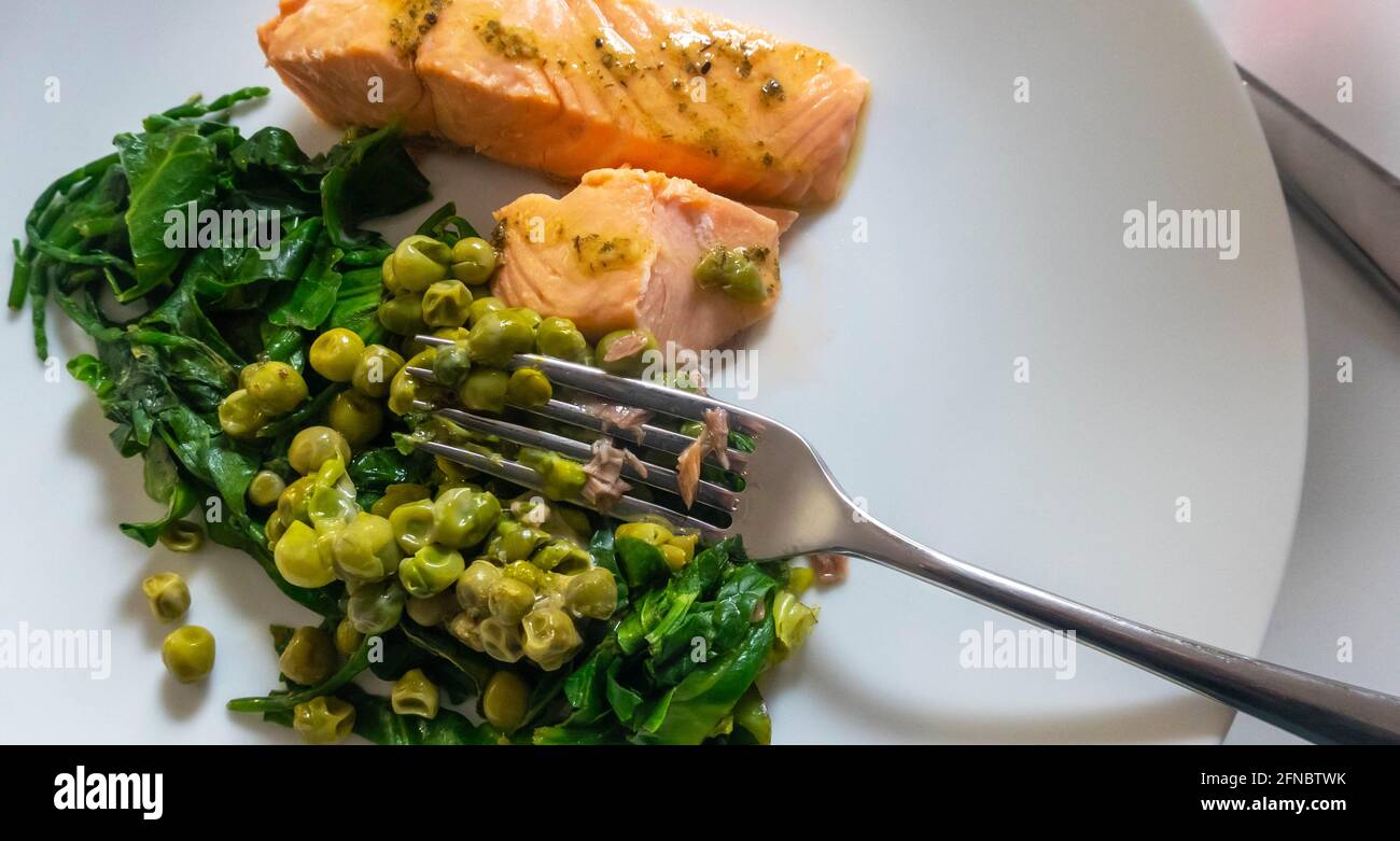 Saumon poché aux pois frais et aux épinards Banque D'Images