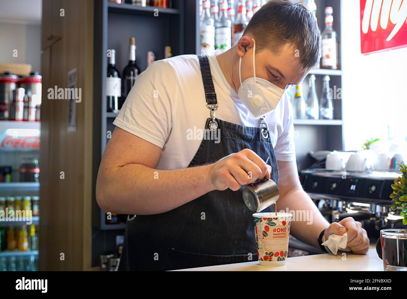 Moscou, Russie – 7 avril 2020 : barman dans un masque médical prépare un café dans un café Banque D'Images