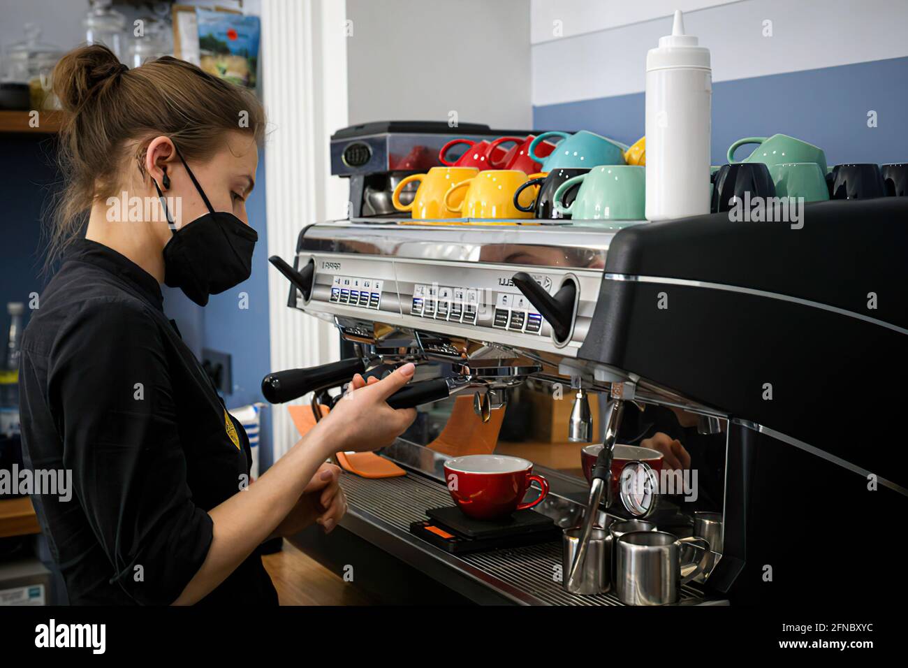 Moscou, Russie – 7 avril 2020 : barman dans un masque médical prépare un café dans un café Banque D'Images
