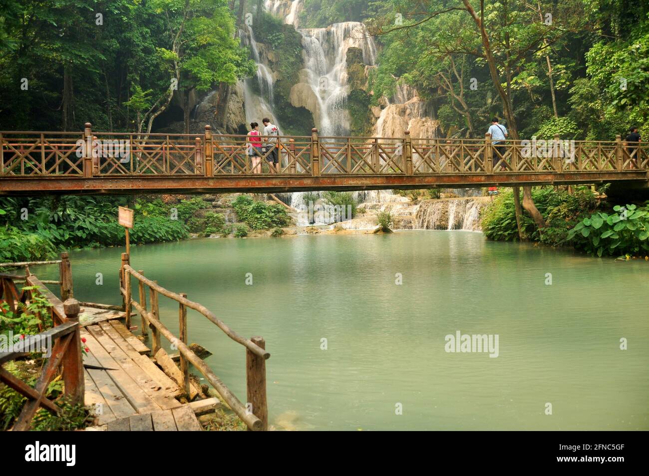 Laotien personnes voyageurs étrangers Voyage visite sur le pont en bois pour Regardez et prenez des photos au point de vue de Tat Kuang si Chutes chutes chutes d'eau à Luangpraban Banque D'Images