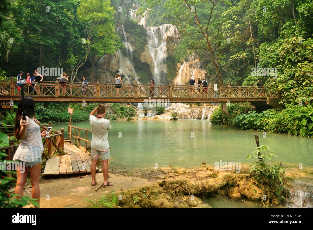 Laotien personnes voyageurs étrangers Voyage visite sur le pont en bois pour Regardez et prenez des photos au point de vue de Tat Kuang si Chutes chutes chutes d'eau à Luangpraban Banque D'Images