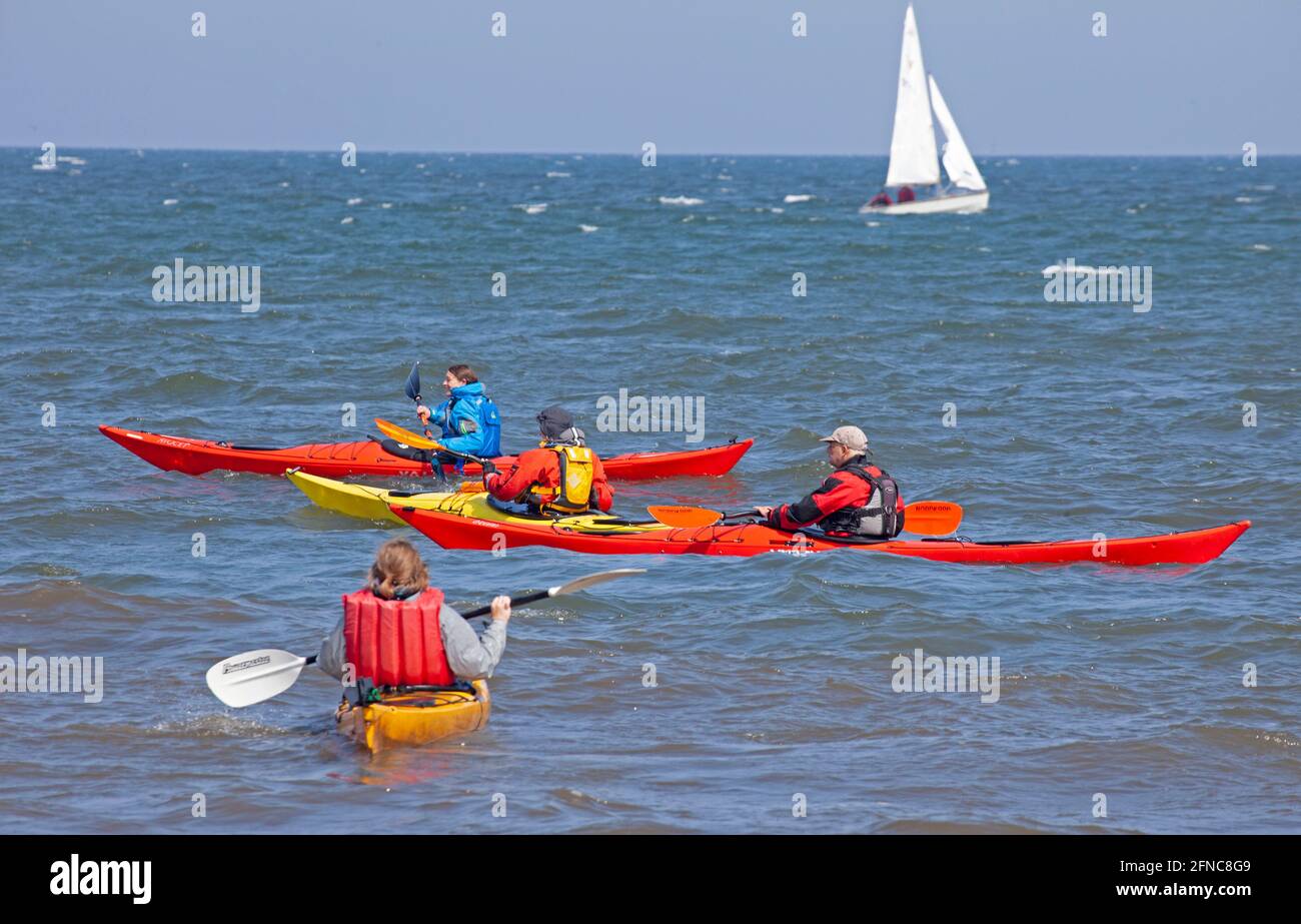 Portobello, Édimbourg, Écosse, météo britannique. 16 mai 2021. Après-midi brillant et terne, avec une température de 12 degrés au bord de la mer relativement animé. Photo : mâles et femelles en kayaks colorés sur Firth of Forth avec un petit yacht en arrière-plan. Crédit : Arch White/Alamy Live News. Banque D'Images